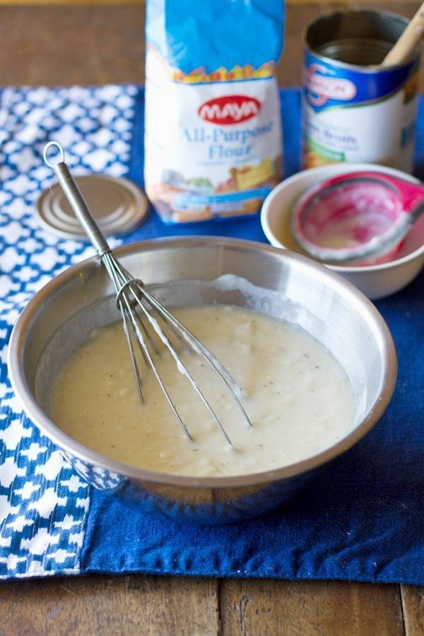 Whisk sitting in a bowl with ingredients for cream of chicken soup. 