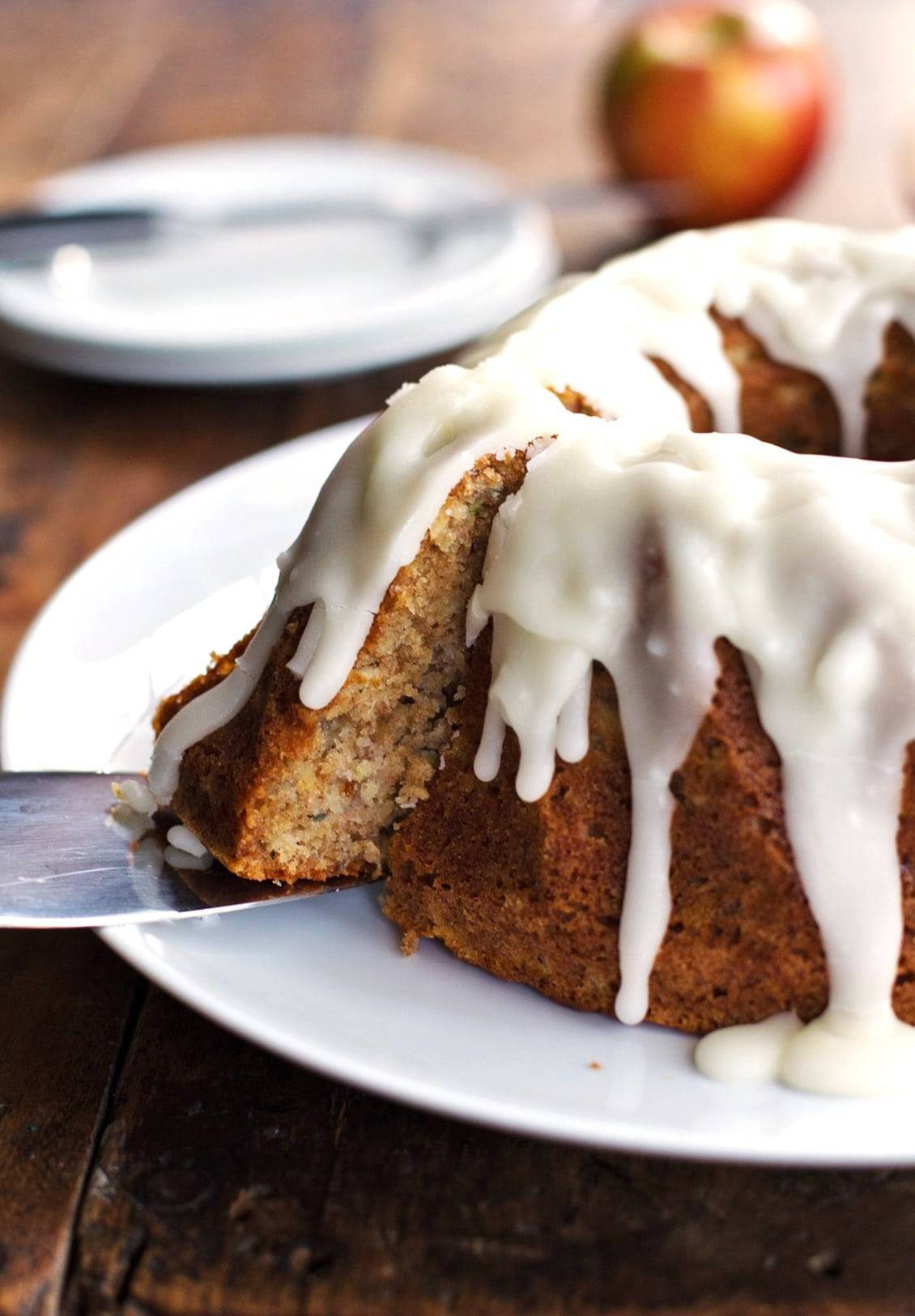 Honey apple bundt cake with glaze on a plate.