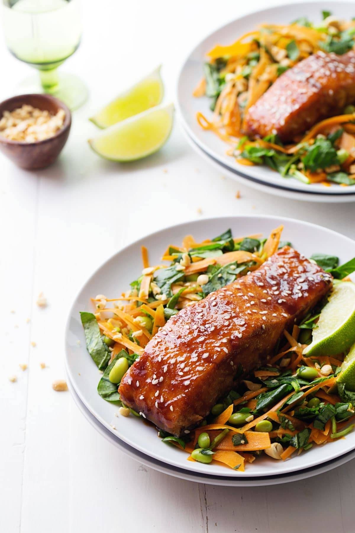 Hoisin Glazed Salmon on white plates on top of salad.