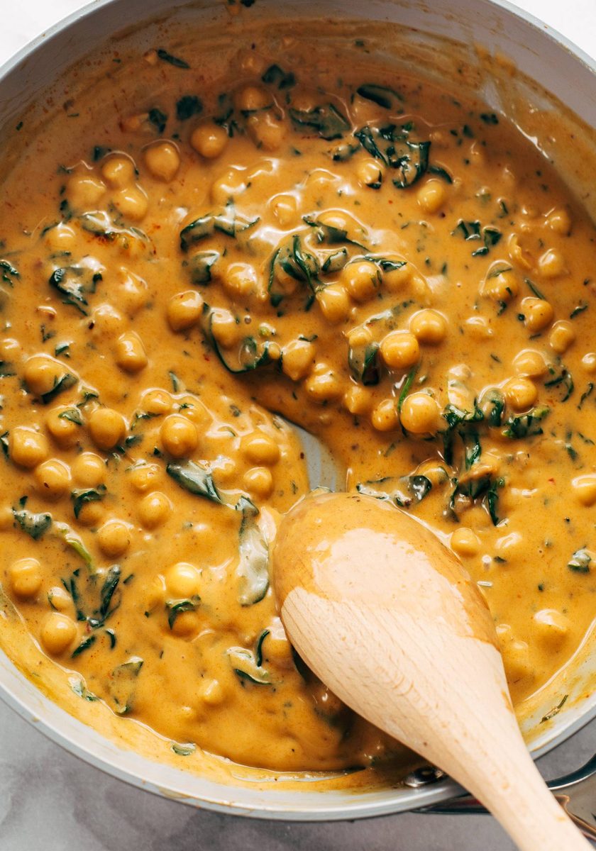 Coconut curry chickpeas with spinach in a pan.
