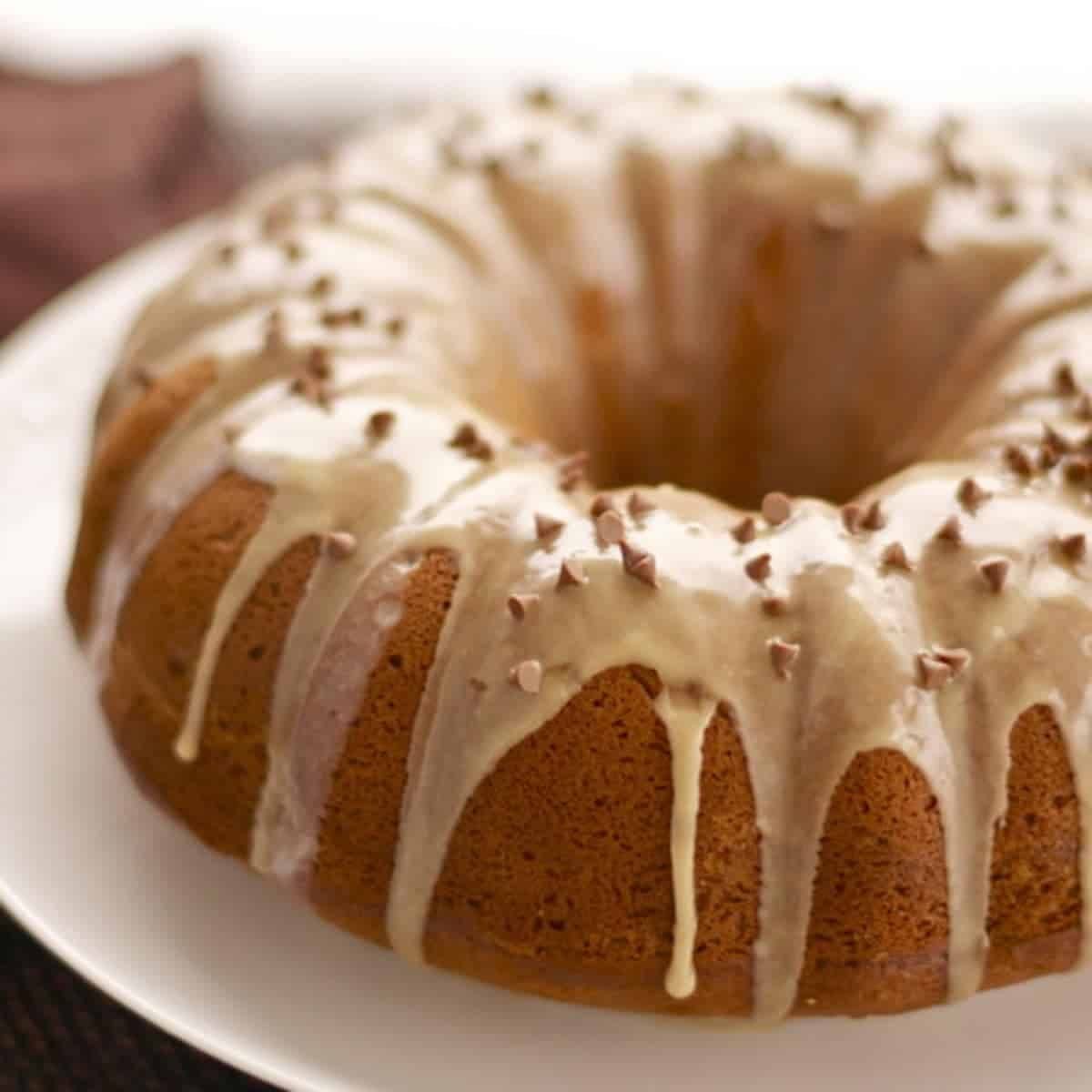 Coffee streusel bundt cake on a plate with drizzle.