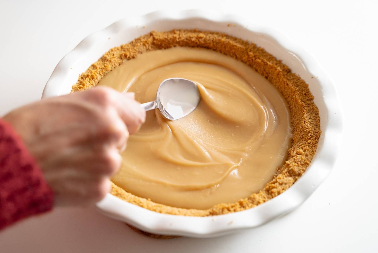 Spreading toffee in graham cracker crust.