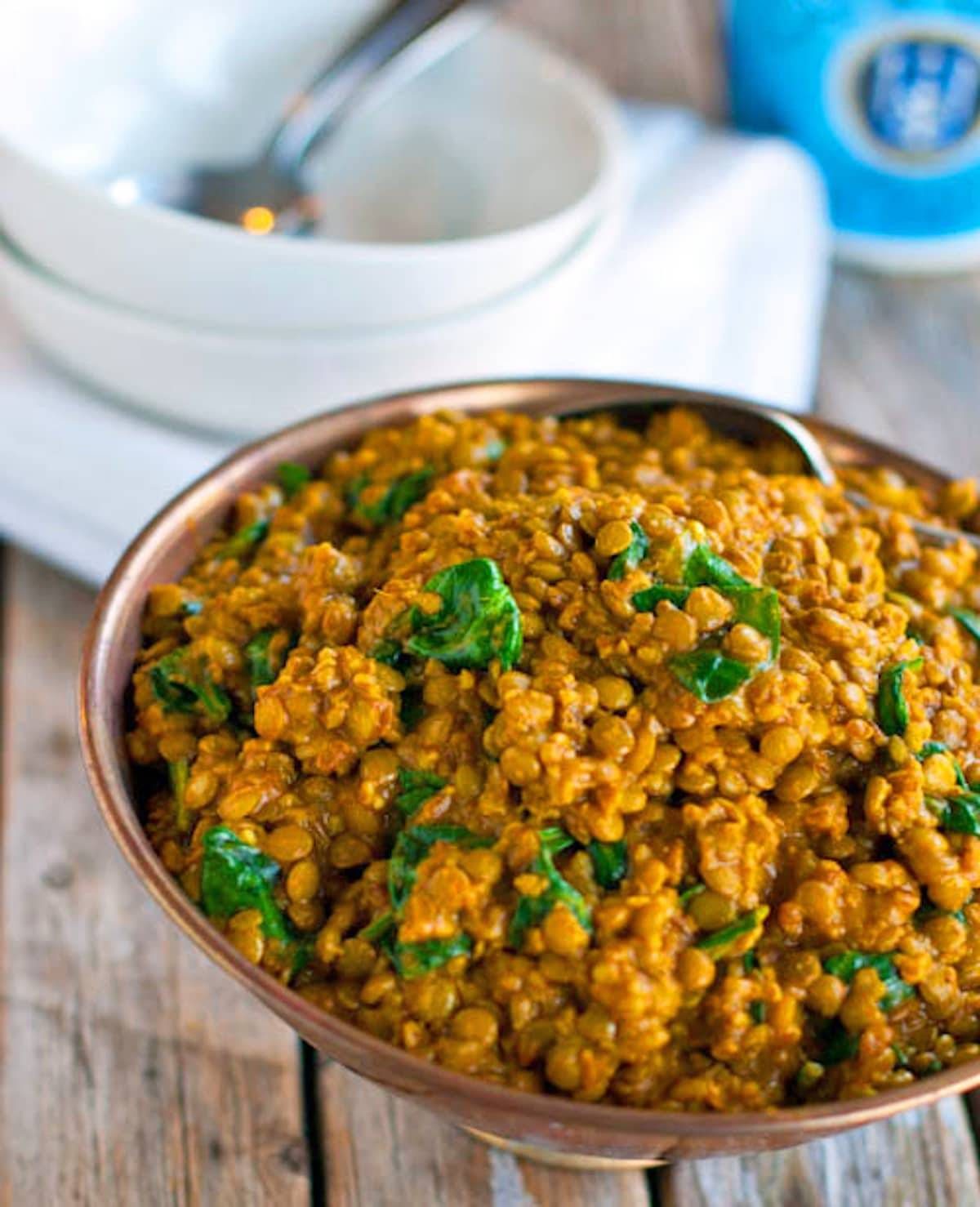 Coconut green curry lentils in a copper bowl.