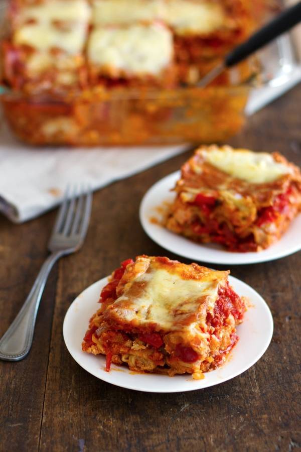 Whole wheat roasted veggie lasagna on two white plates.