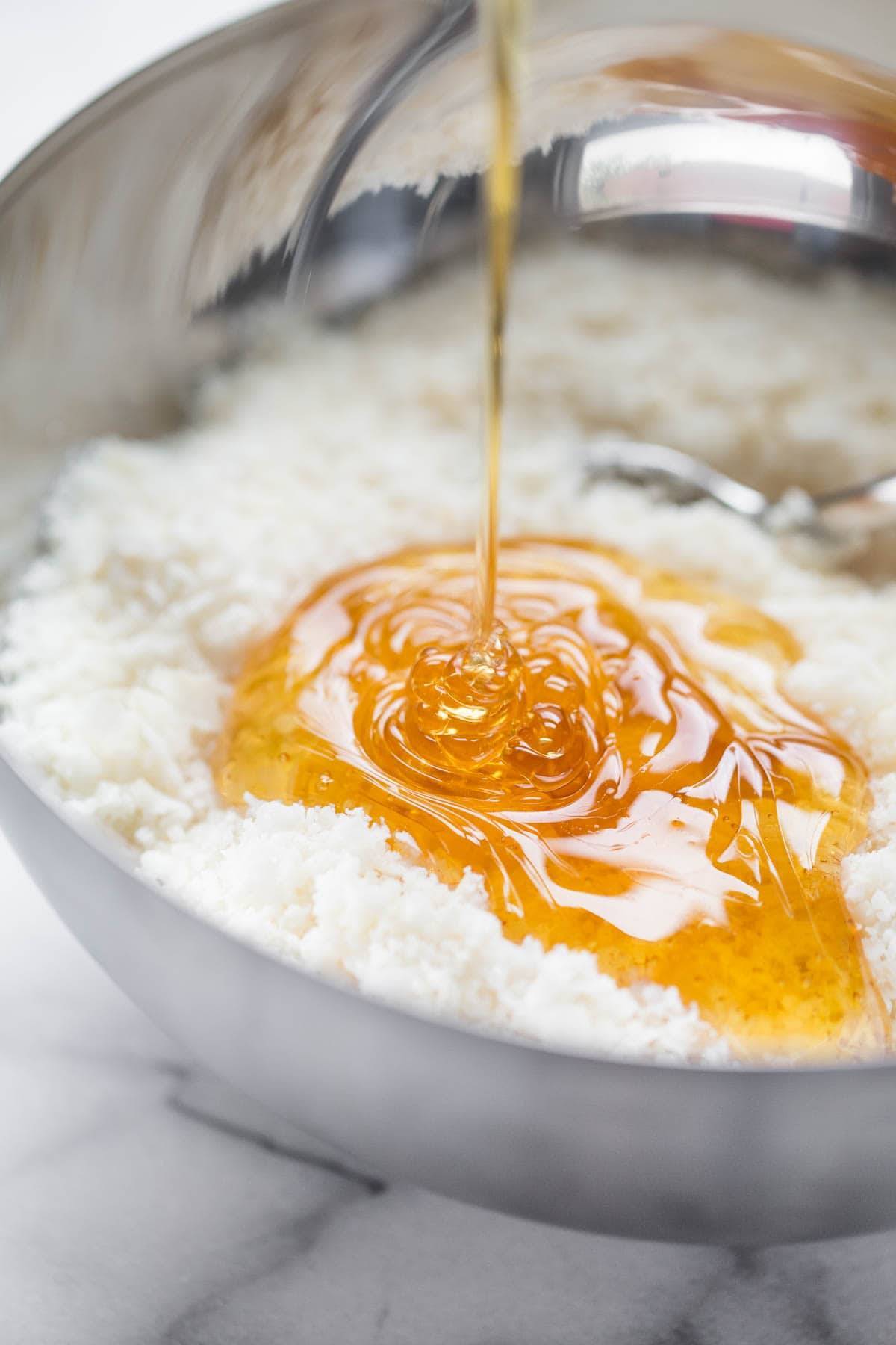 Honey pouring over coconut shreds.