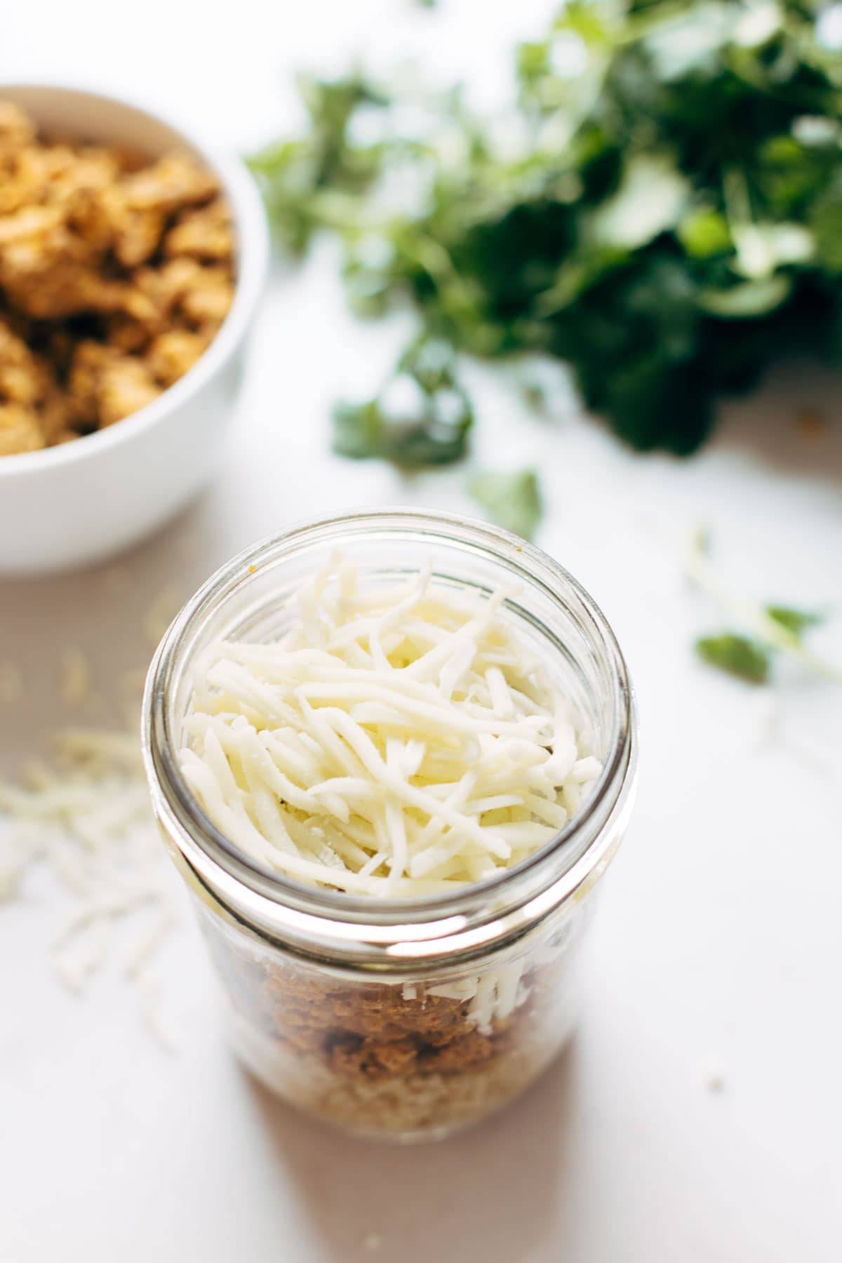 Southwest Turkey Breakfast Stacks in a jar with cheese topping.
