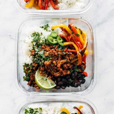 Vegan burrito bowls with rice in glass containers.